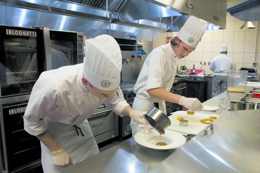 Students Jeff Schuarce and Gavin Fritz (left to right) show close attention to detail as they prepare one of the dishes offered for dinner at the American Harvest Restaurant. The Harvest provides students with real world experience needed to work in the highly competitve culinary industry.
(Photo by Chrissy Begle, Layout And Design Editor)