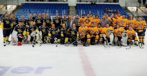 Members of the Schoolcraft College and Michigan State Troopers (MSP) Hockey teams gather at center ice for a group photo at the conclusion of the game. The MSP Troopers beat the Ocleots 8-3.