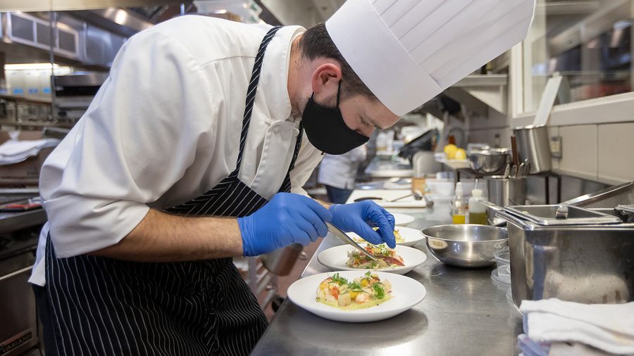 Austin Hannah puts the finishing touches on his seafood appetizer that consisted of: butter-poached lobster; butter-poached scallops; green leek puree as a base; pickled leeks; ricotta; and pancetta (a sort of cured bacon) during a practice session inside the Schoolcraft Culinary Arts kitchen.
