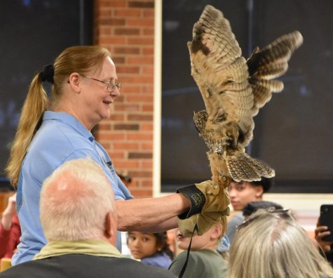 Barb Rogers of the Wildlife Recovery Association presents an owl to audience on Wednesday, September 28 at Schoolcraft College in Livonia, MI during the Birds of Prey Show.