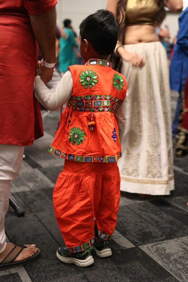 A child watches as the crowd dances the garba, a type of Indian dance commonly performed at festivals and on other special occasions, October 8, 2022  in the DiPonio room of the VisTaTech Center