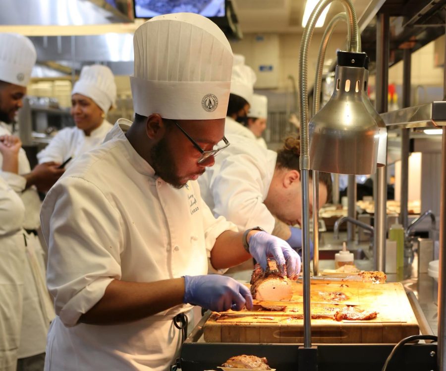 Culinary Arts student, Keenan Lowe prepares a pork dish at the 2023 Culinary Extravaganza on February 23, 2023 in the Vistatech Center at Schoolcraft College.