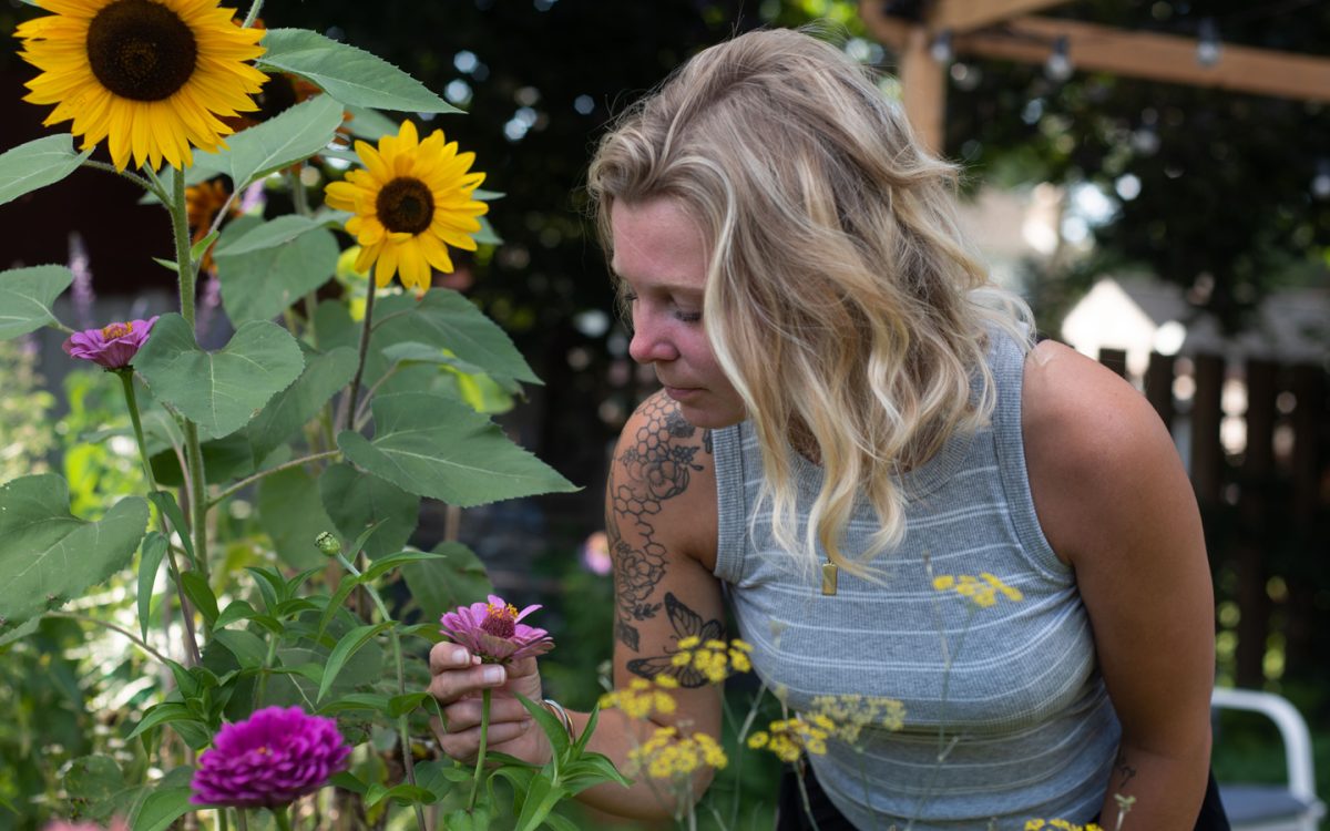 Alyssa Braun enjoys investigating her flower plants in her backyard garden.
