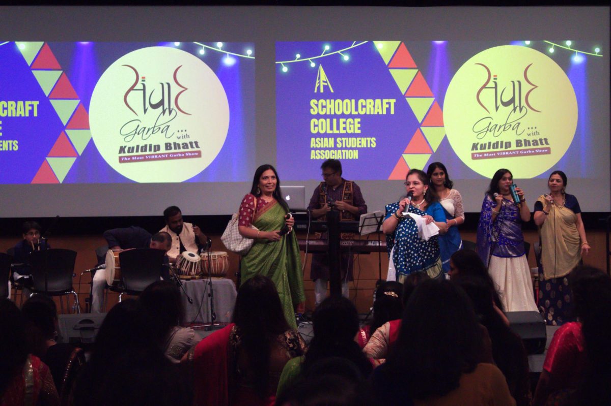 Anna Maheshwari (green dress) speaks to the crowd gathered inside the DiPonio Room at the Navratri Garba on Oct. 28, 2023 at Schoolcraft College.