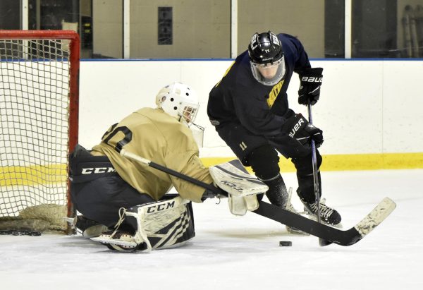 A prospect tries to bury the puck on net while the goaltender poke checks it during the Schoolcraft College Ice Hockey team prospects skate at Modono Ice Arena in Westland, Michigan on Jan. 28, 2024.