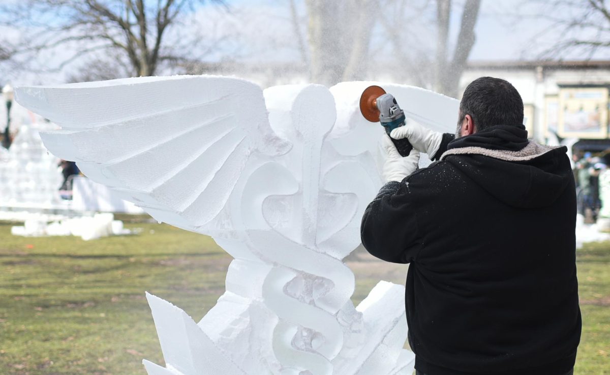 A sculptor carves the Caduceus, the symbol of medicine, at the Plymouth Ice Festival Feb. 3, 2024 in downtown Plymouth, Michigan.

