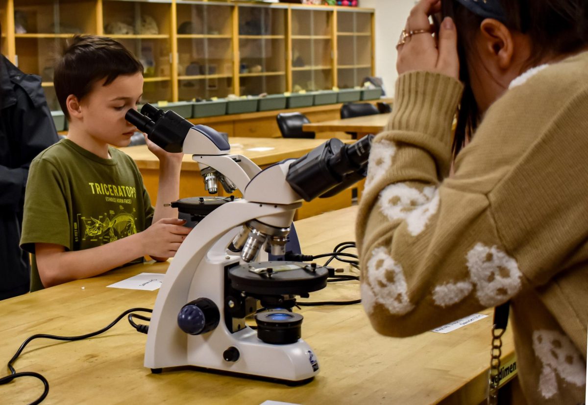 Attendees take a closer look at rocks and minerals under the microscopes  at the Optical World of Minerals workshop on March 14, 2024 from 6-7 p.m. in the Forum Building.