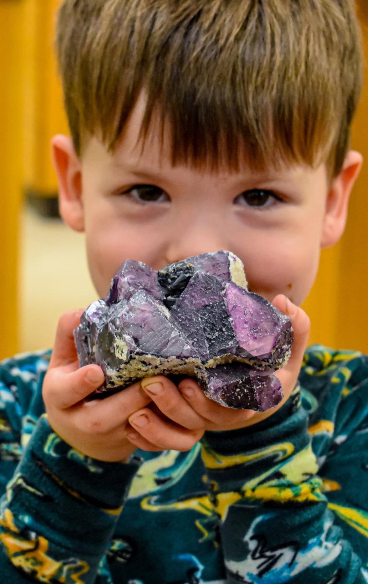 A young attendees shows off his favorite mineral, an amethyst, at the Optical World of Minerals workshop on March 14, 2024 in the Forum Building.