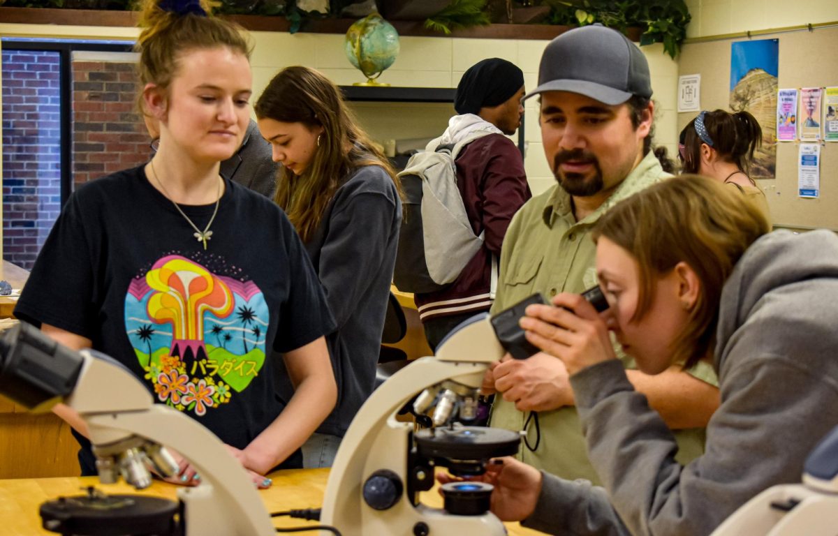 Geology Professor Samer Hariri watches as attendees explore various minerals inside the Geology Lab at the Optical World of Minerals workshop on March 14, 2024 in the Forum Building.