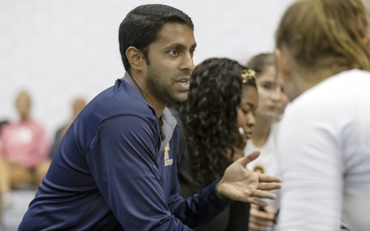 Head Coach Jaison George of the Schoolcraft Women’s Volleyball Team speaks to his players during a time out.  He has a motto of never give up. (photo courtesy of Schoolcraft College)